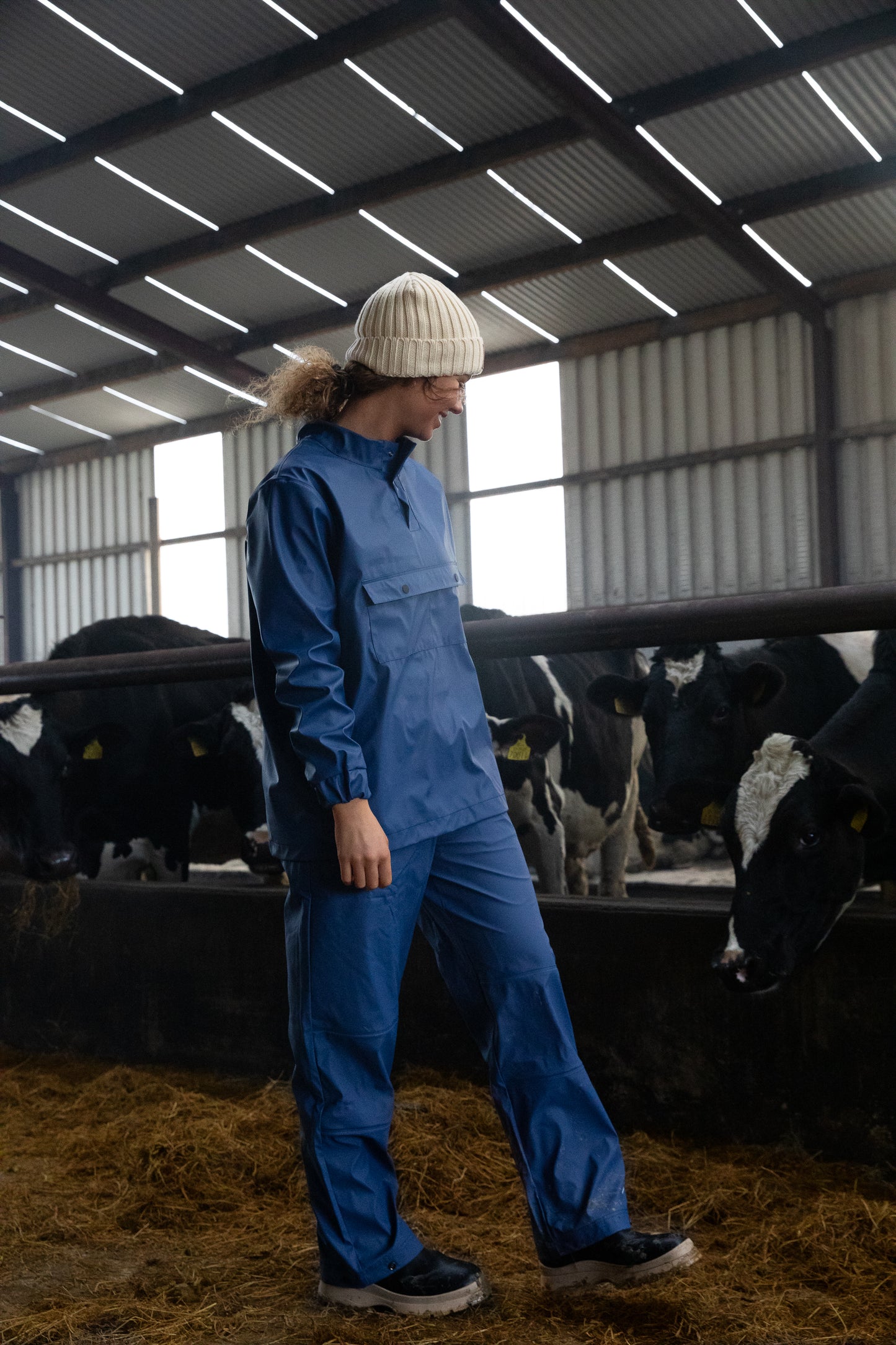 "Women walking in cow shed wearing Wawets navy/blue dairy top with double pockets in front for drying off"